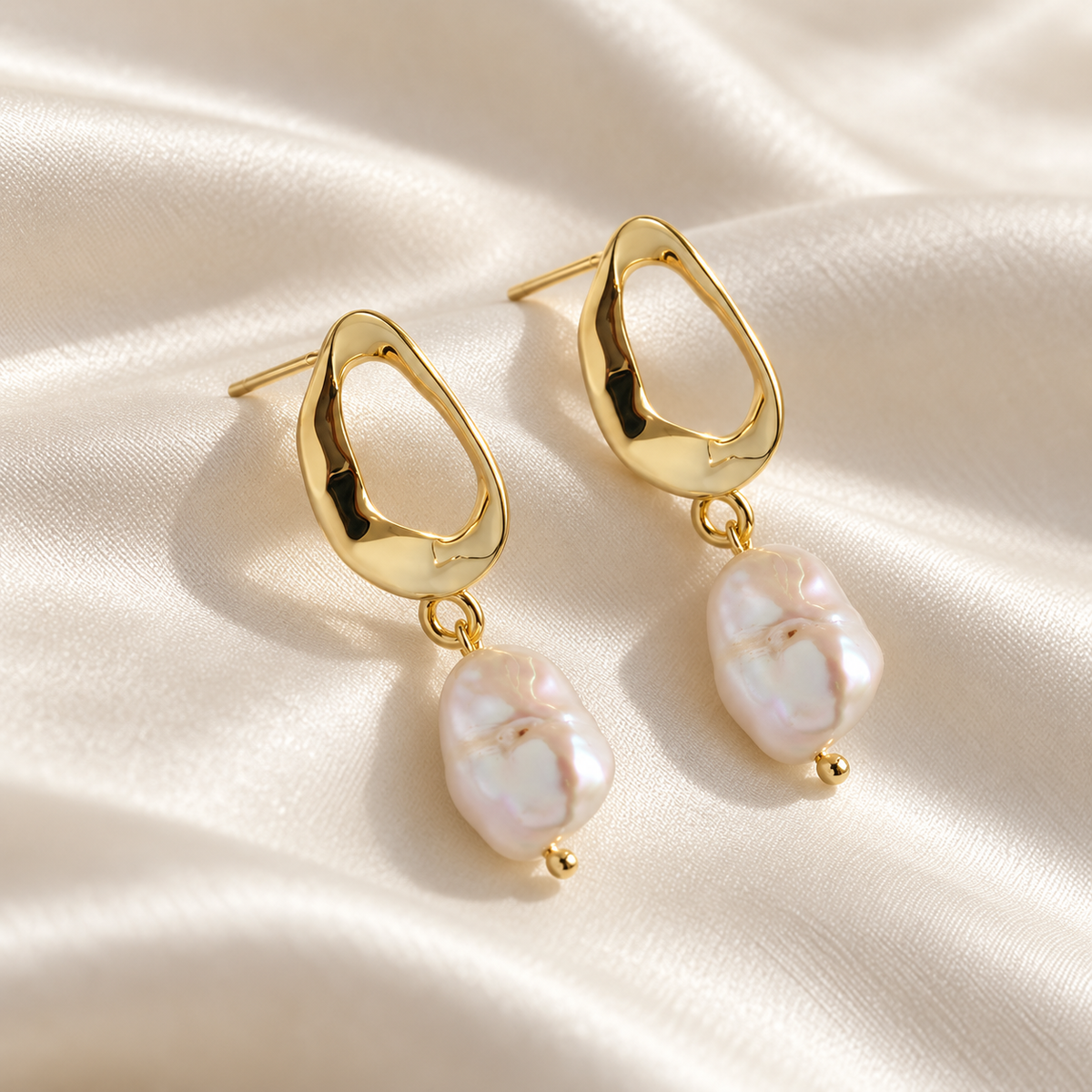 Digital product visualisation of pearl drop earrings in gold finish on ivory silk, macro view