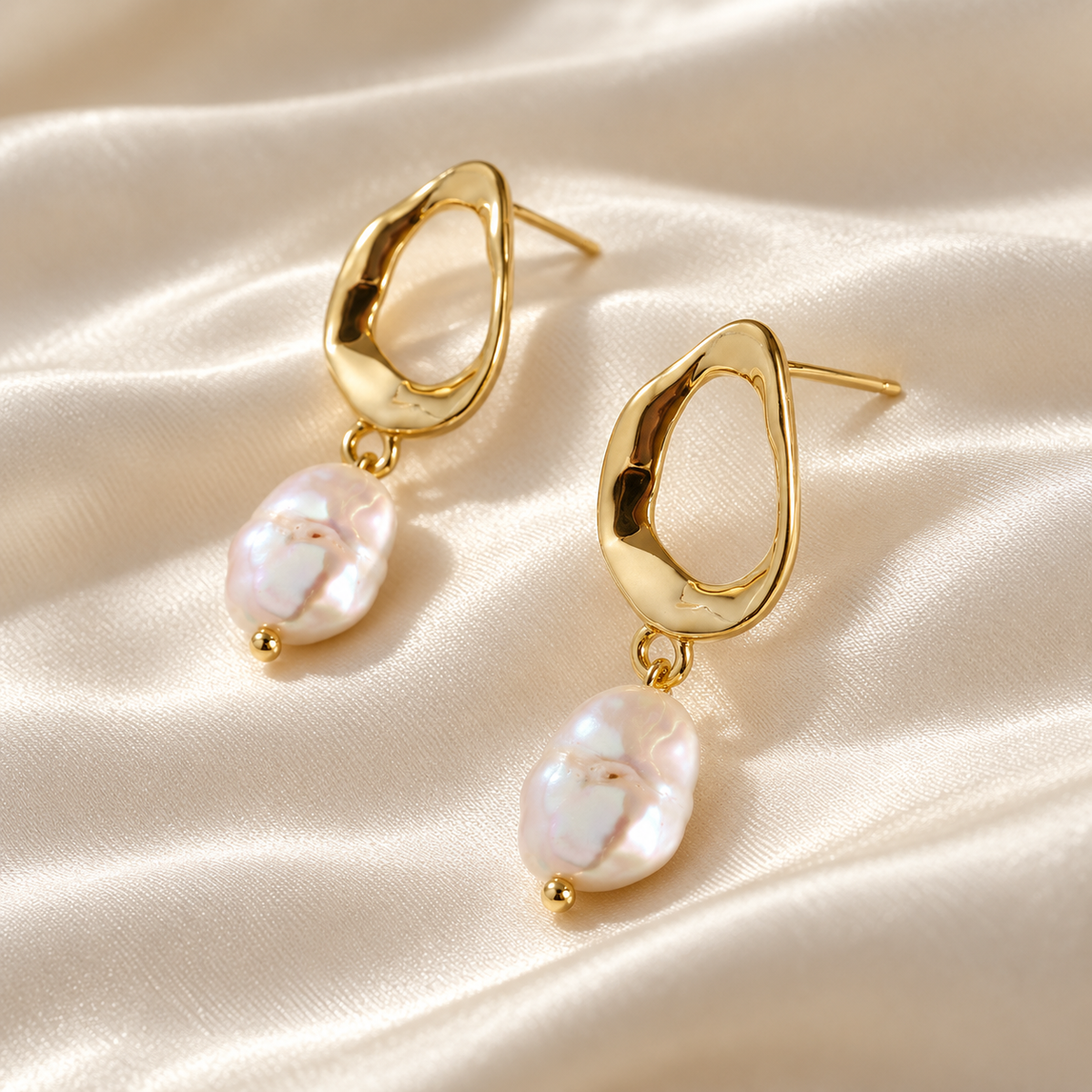 Digital product visualisation of pearl drop earrings in gold finish on ivory silk, side view