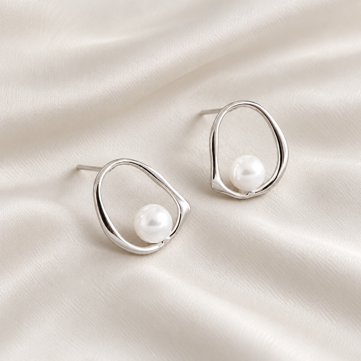 Digital product visualisation: silver shell pearl stud earrings on ivory silk; macro view