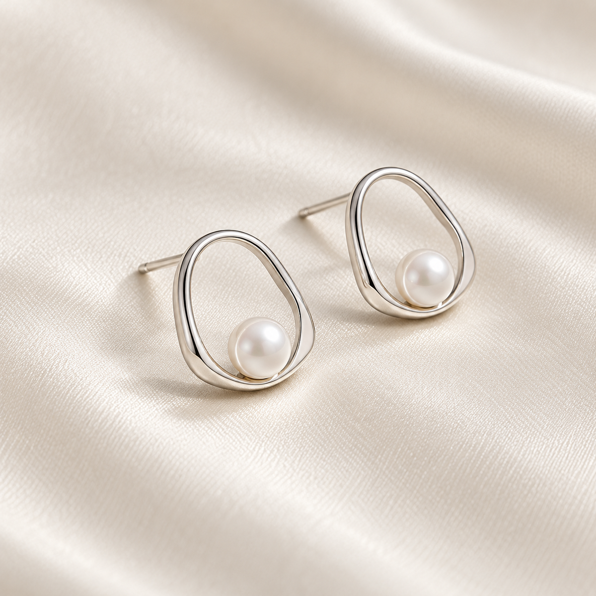 Digital product visualisation: silver shell pearl stud earrings on ivory silk; side view