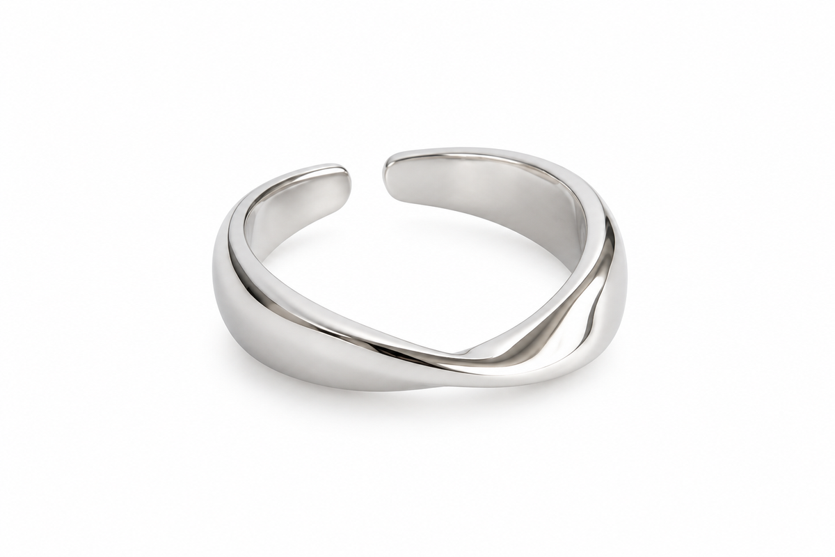 Sculpted crossing silver ring on white studio background