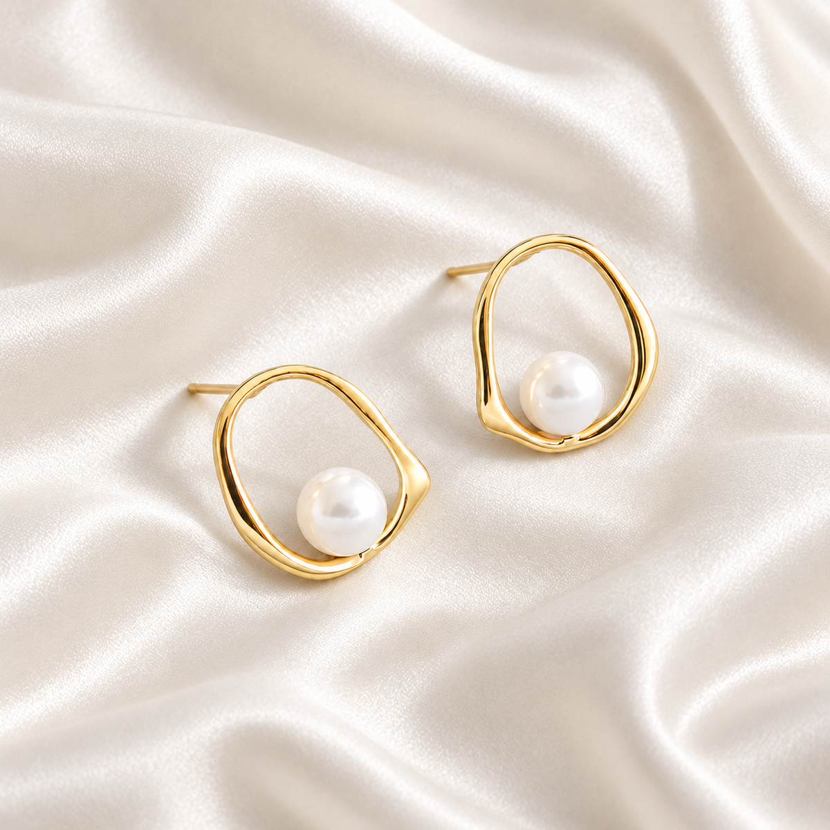 Digital studio visualisation of Yellow Gold shell pearl studs on ivory silk, overhead