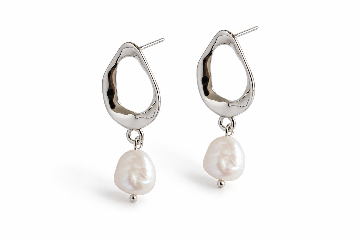 Silver open teardrop pearl earrings on white studio background